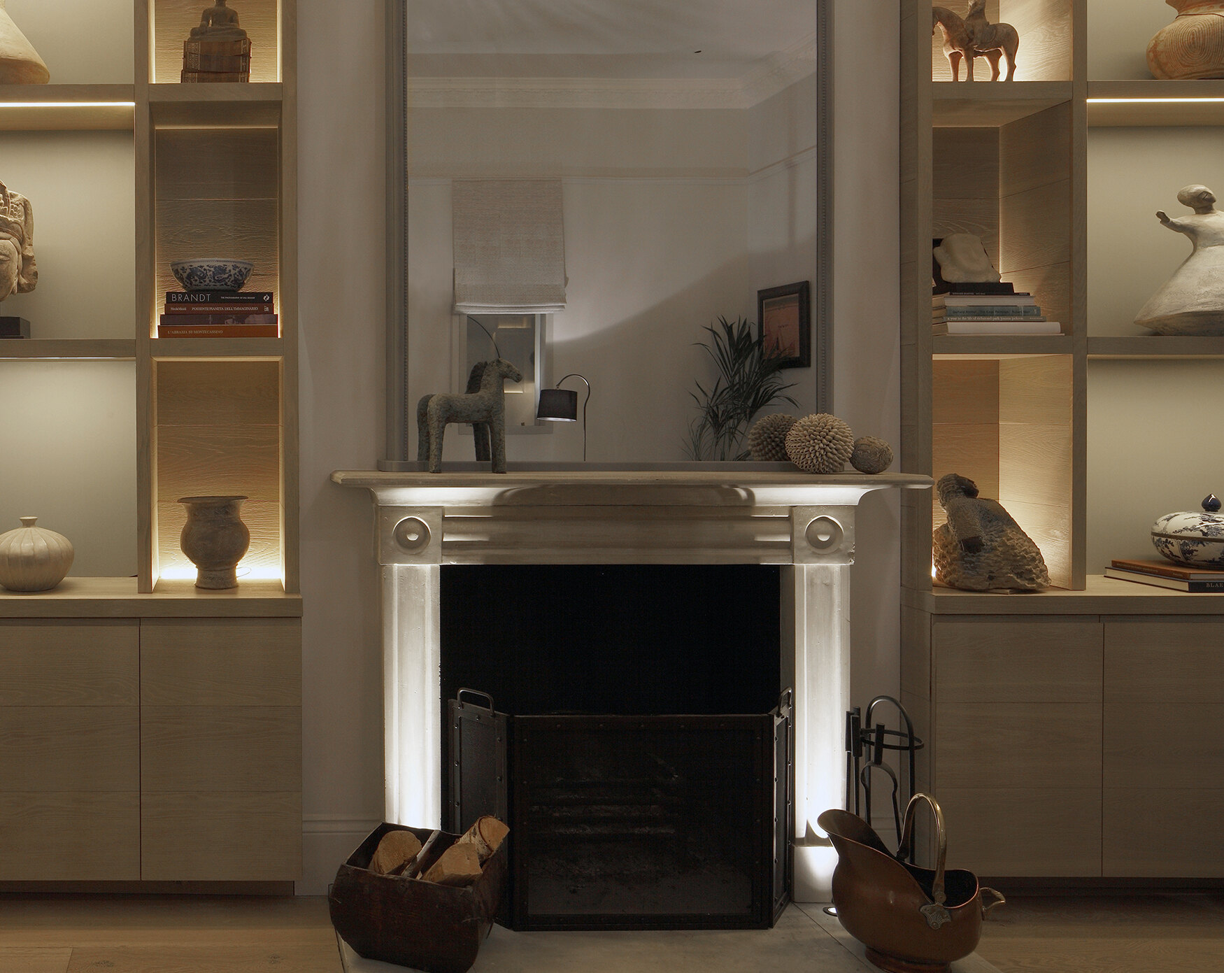 Tiny floor uplights washing a fireplace wall